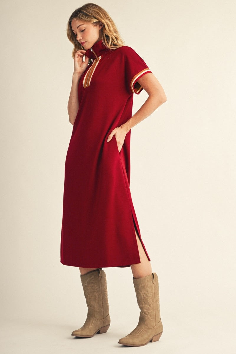 woman wearing a red polo-style dress with side slits and contrasting stripes, paired with beige cowboy boots