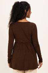 woman wearing a brown long sleeve maternity top with a peplum style and a relaxed fit from the back