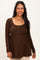 woman wearing a brown ribbed maternity top with button details and a visible baby bump