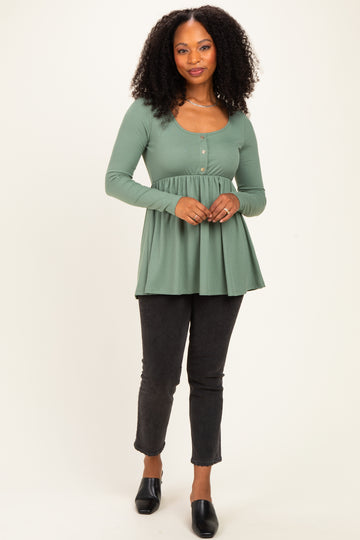 woman wearing a green ribbed long sleeve peplum top with buttons and black skinny jeans