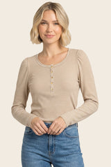 woman wearing a beige striped long sleeve top with button details and a fitted style, paired with blue jeans