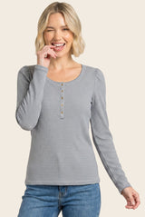 woman wearing a navy and white striped long sleeve henley top with button details and smiling