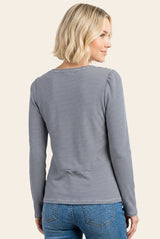 woman wearing a fitted long sleeve striped top, viewed from the back, paired with blue jeans