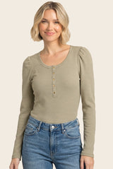 woman wearing a striped long sleeve henley top with buttons and puff sleeves paired with light wash jeans