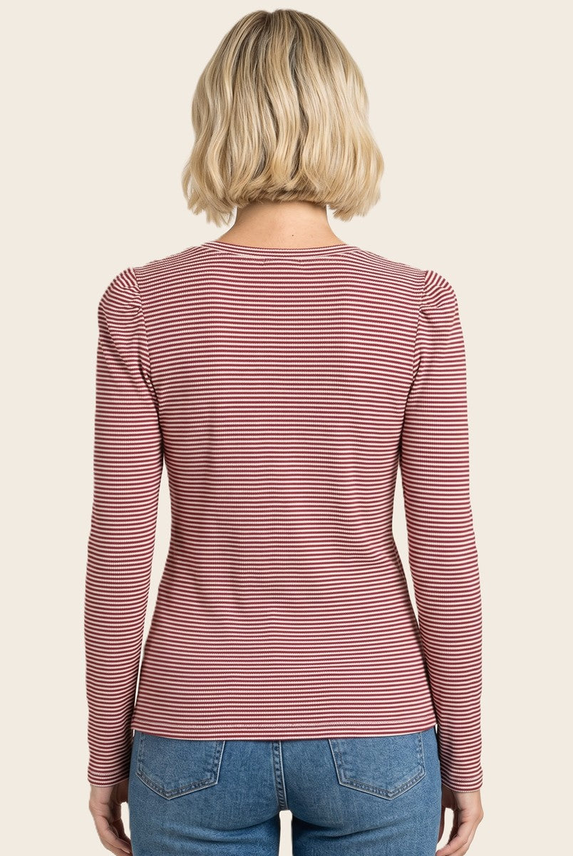 woman wearing a red and white striped long sleeve top, viewed from the back
