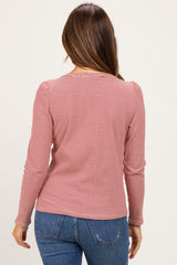 woman wearing a red and white striped long sleeve maternity top, viewed from the back with casual blue jeans