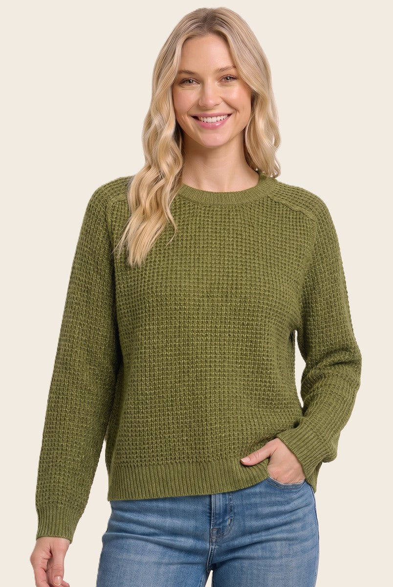 woman wearing a green textured knit sweater with a crew neckline and long sleeves, smiling