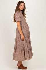 woman wearing a dusty rose tiered maternity dress with short sleeves and a visible baby bump