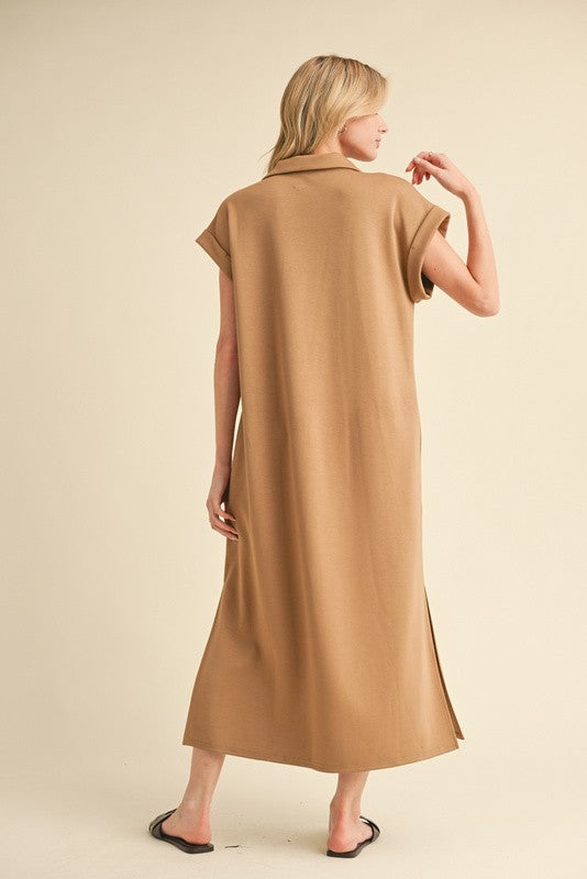 woman wearing a brown maxi dress with short sleeves and side slits, viewed from the back