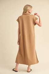 woman wearing a brown maxi dress with short sleeves and side slits, viewed from the back