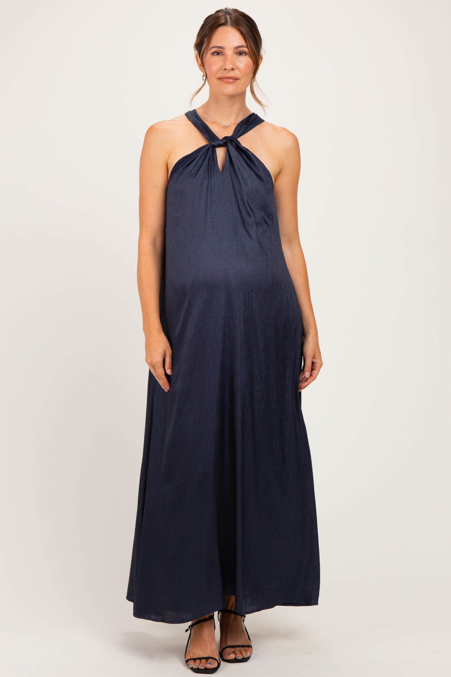 woman wearing a navy blue halter neck maternity maxi dress with a keyhole detail and visible baby bump