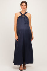 woman wearing a navy blue halter neck maternity maxi dress with a keyhole detail and visible baby bump