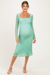 woman wearing a mint green long sleeve maternity dress with a square neckline and a fitted silhouette, showing her baby bump