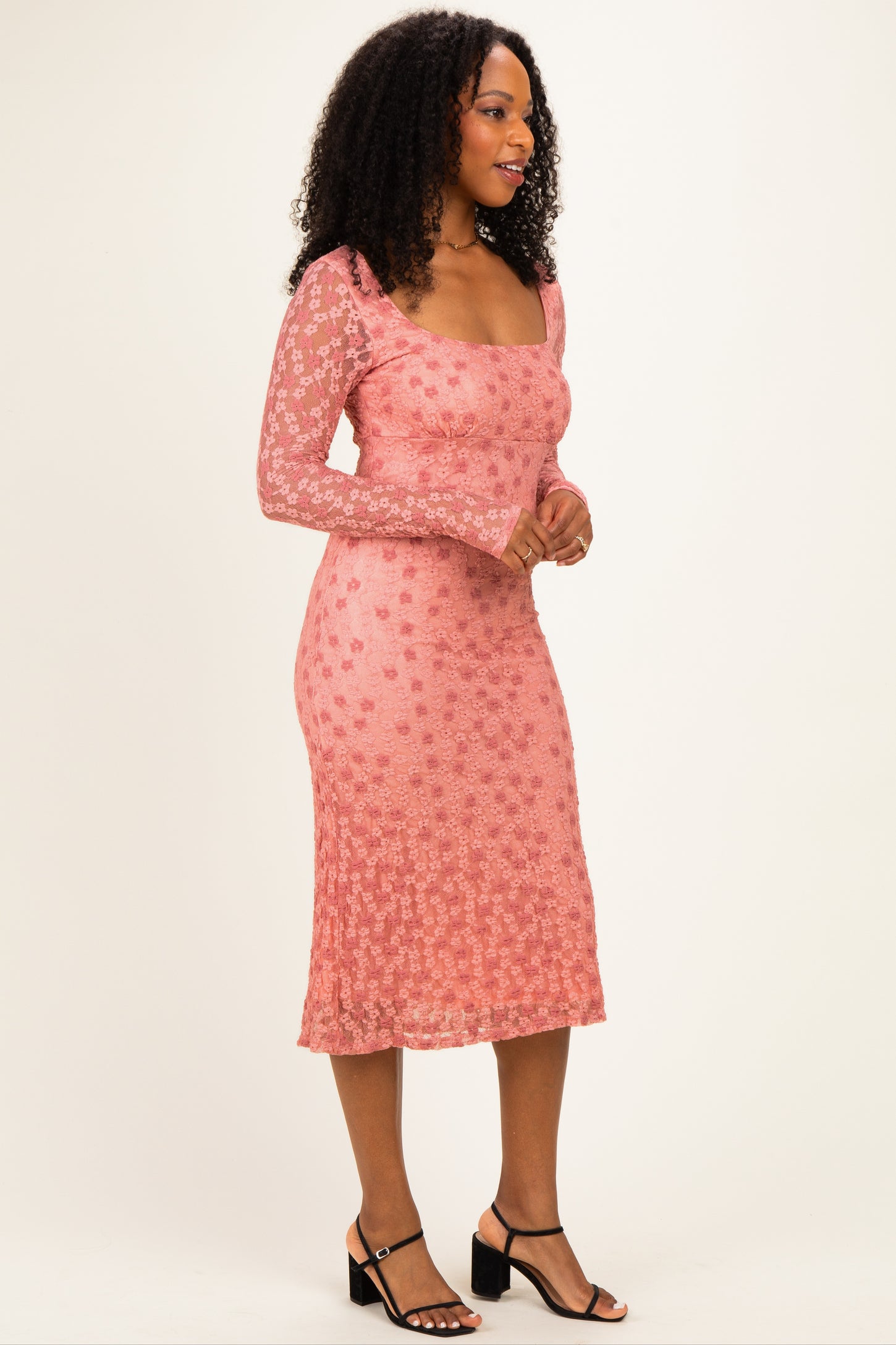 woman wearing a pink floral lace midi dress with long sleeves and a square neckline