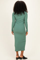 woman wearing a long sleeve green maxi dress with a fitted silhouette and side slit, seen from the back