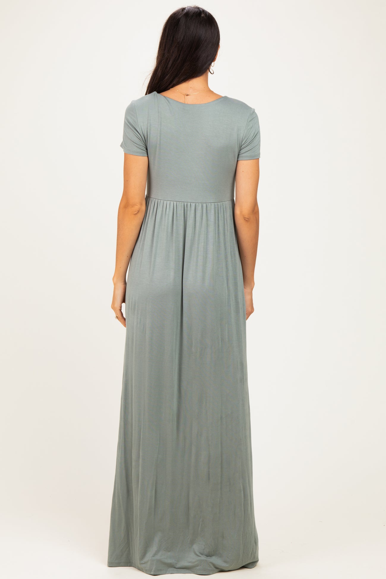 woman wearing a sage green short sleeve maxi dress with a flowing skirt and a relaxed fit