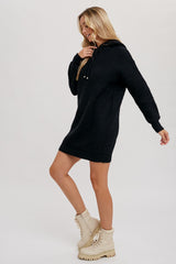woman wearing a black knitted hoodie dress with long sleeves and paired with beige lace-up combat boots