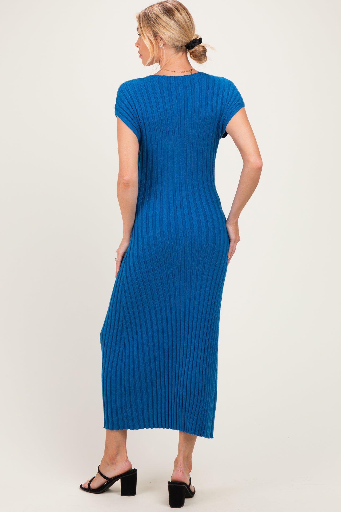 woman wearing a ribbed blue maternity maxi dress with short sleeves and a fitted silhouette
