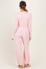 woman wearing a pale pink long sleeve maternity pajama set with loose-fitting pants and a relaxed fit