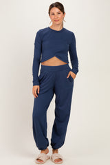 woman wearing a navy blue maternity long sleeve crop top and matching jogger pants