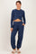 woman wearing a navy blue maternity long sleeve crop top and matching jogger pants