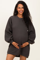 woman wearing a charcoal gray maternity sweatshirt dress and holding her baby bump