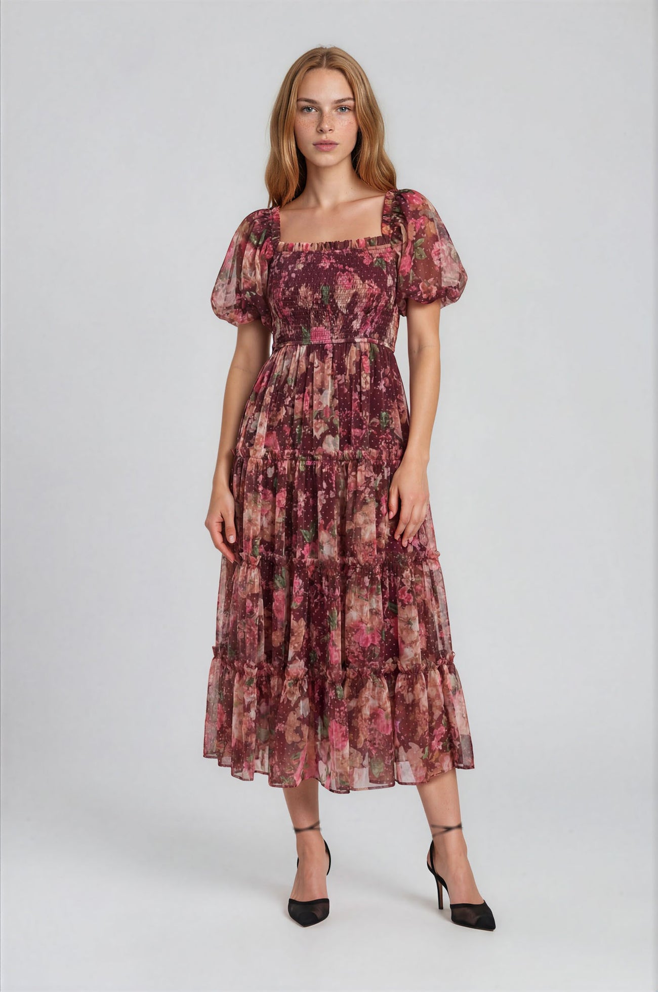 woman wearing a floral maxi dress with puff sleeves and a tiered skirt