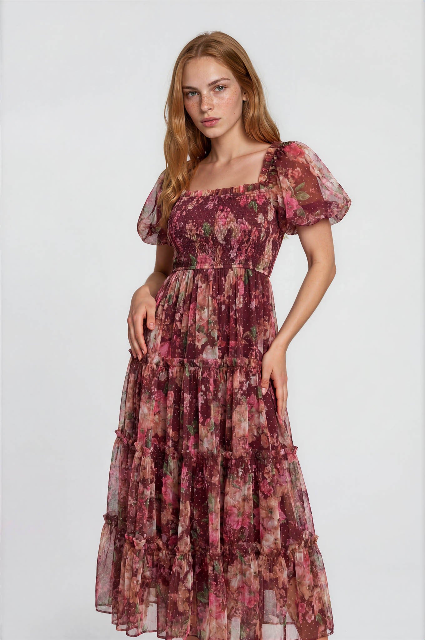 woman wearing a floral print maxi dress with puff sleeves and tiered ruffles