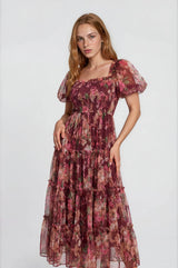 woman wearing a floral print maxi dress with puff sleeves and tiered ruffles