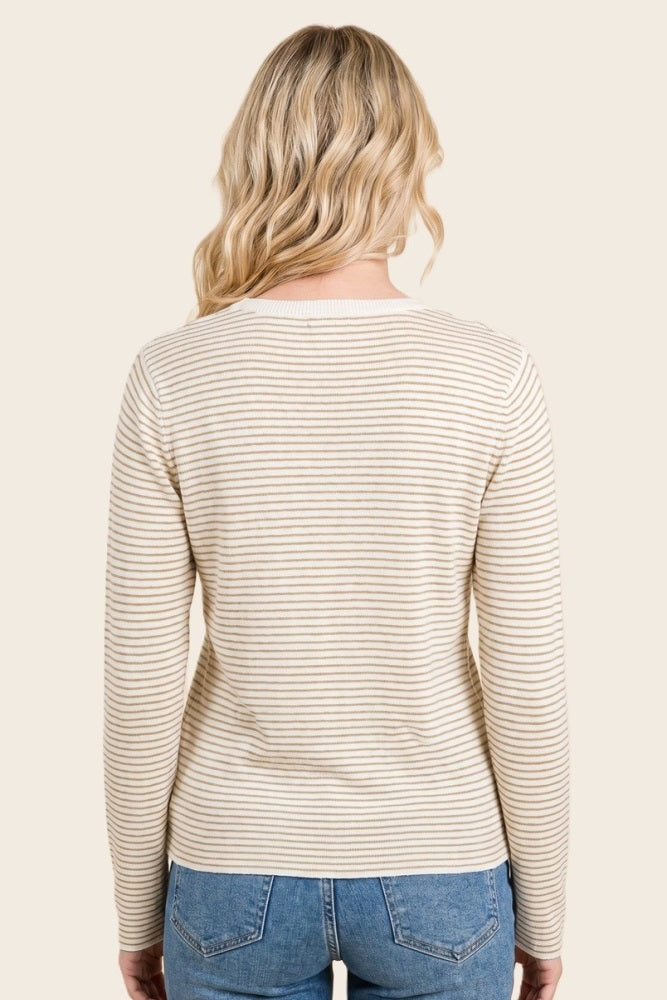 woman wearing a cream and beige striped long sleeve sweater, seen from the back