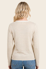 woman wearing a cream and beige striped long sleeve sweater, seen from the back