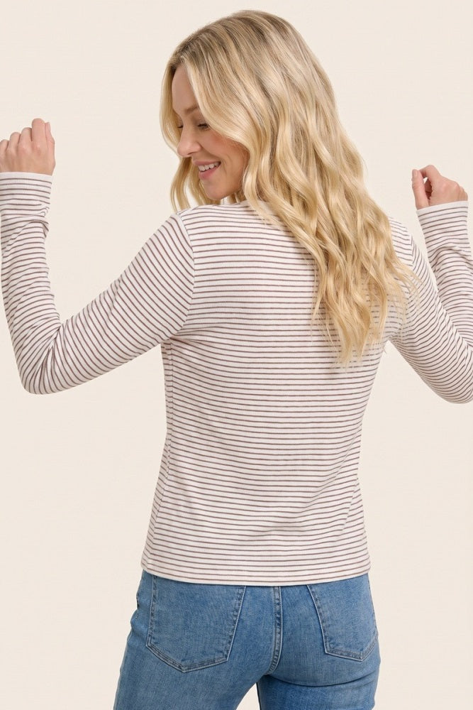 woman wearing a thin striped long sleeve top with a round neck and back view, paired with light blue jeans
