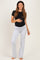 woman wearing a black short sleeve maternity top and gray maternity pants, with her baby bump visible