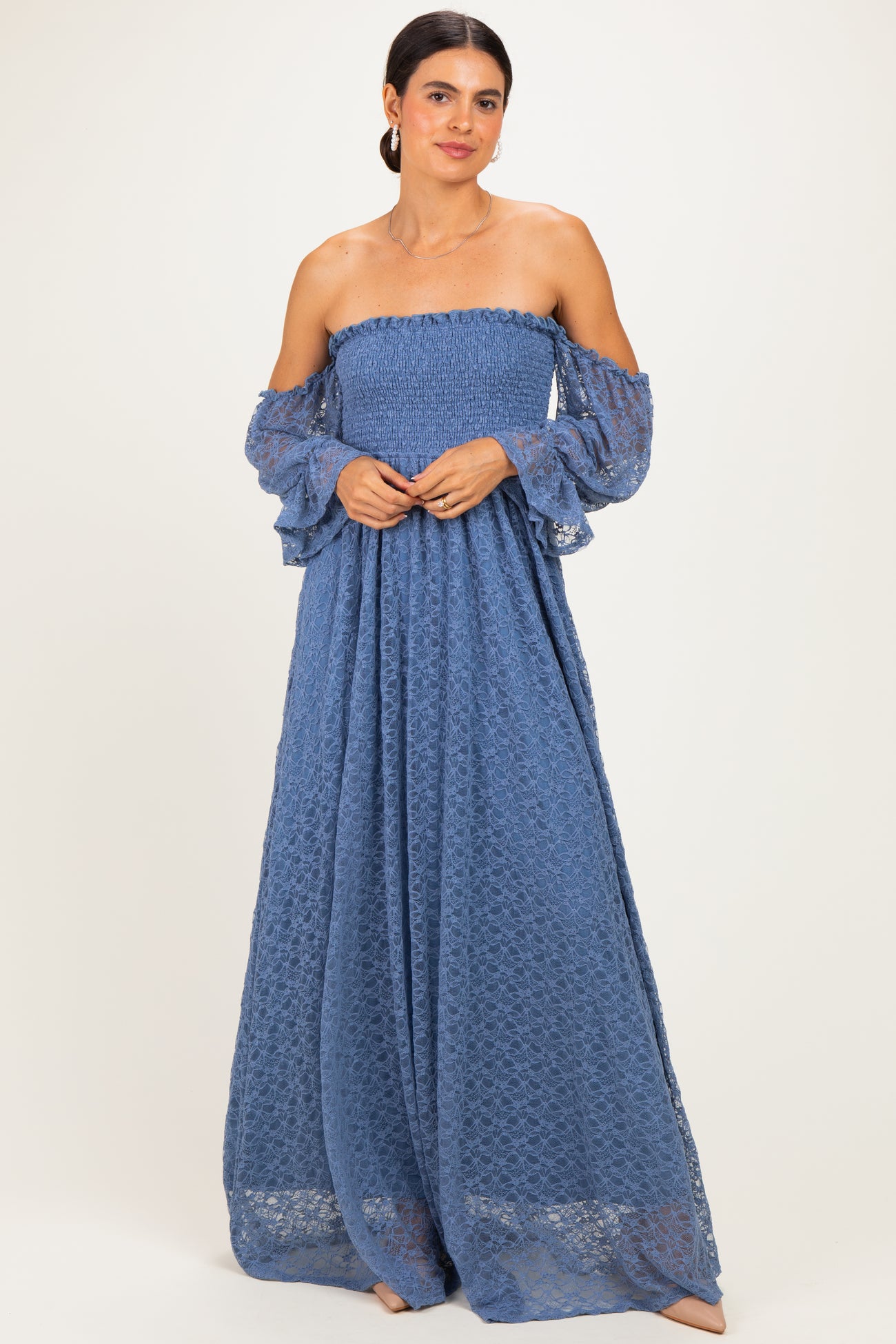 woman wearing a blue off-the-shoulder maxi dress with lace details and flared sleeves