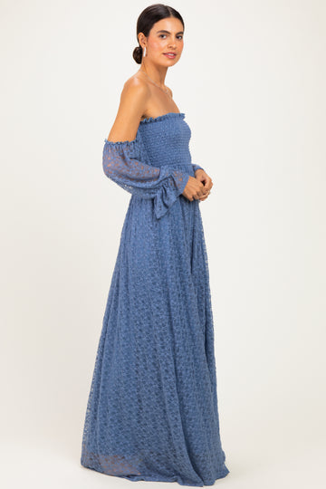 woman wearing a blue off-shoulder maxi dress with long sleeves and a smocked bodice