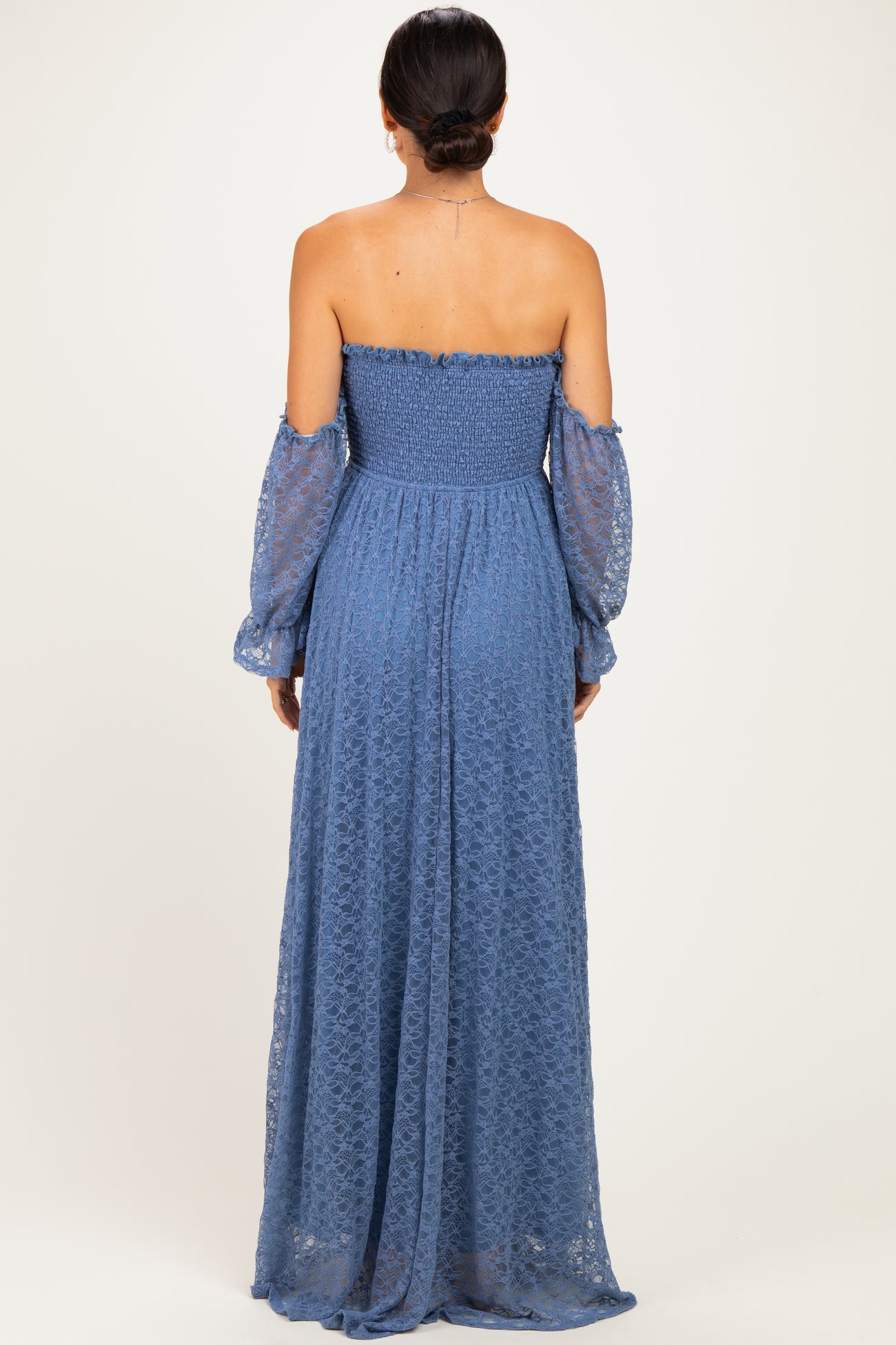 woman wearing a back view of a blue off-the-shoulder long lace maxi dress with puff sleeves
