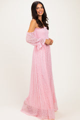 woman wearing a pink off-the-shoulder maxi dress with long sleeves and a smocked bodice