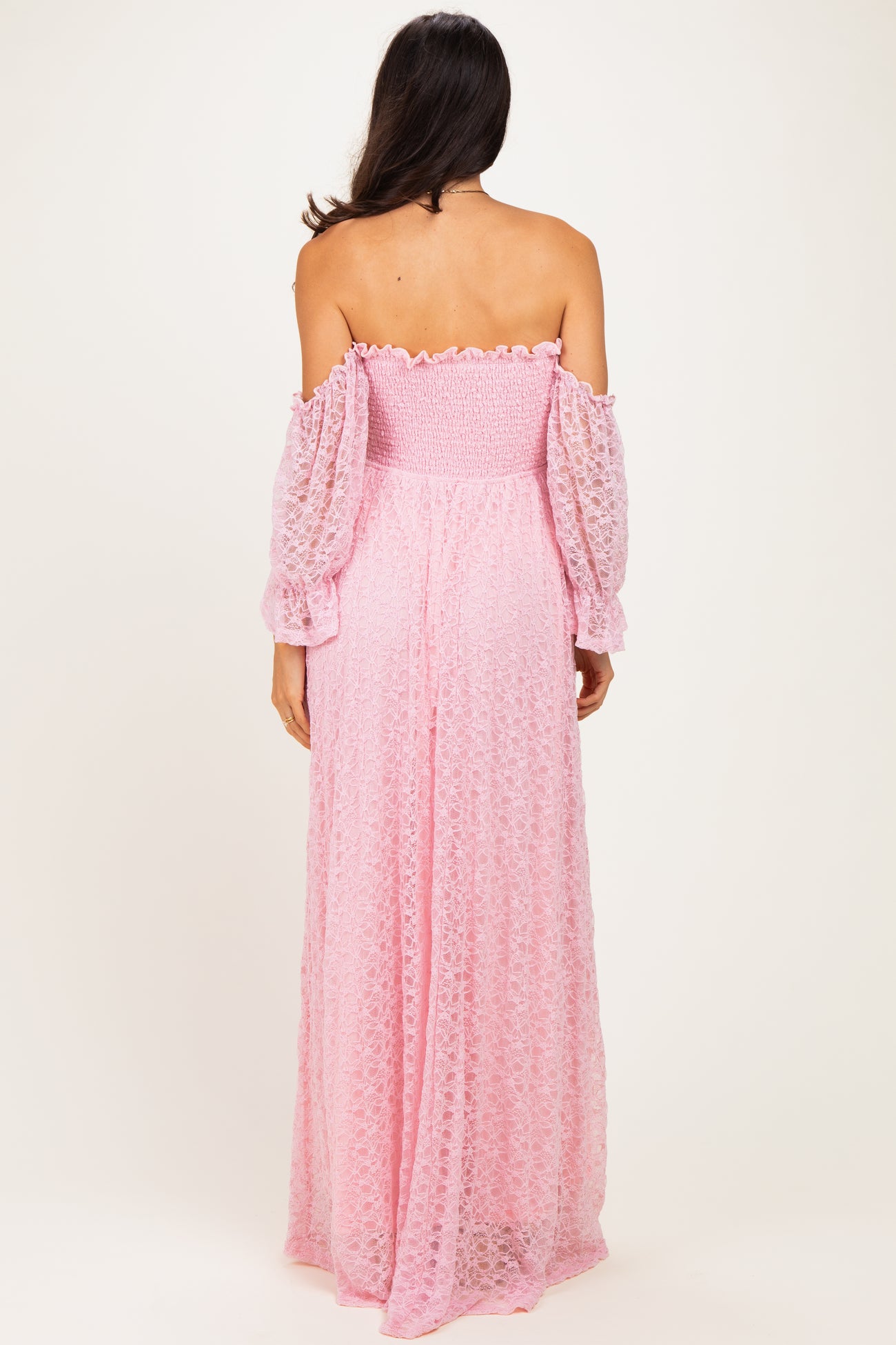 woman wearing a pink off-the-shoulder maxi dress with puffed sleeves and smocked bodice, shown from the back