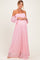 woman wearing a pink off-the-shoulder maternity dress with lace details and a visible baby bump