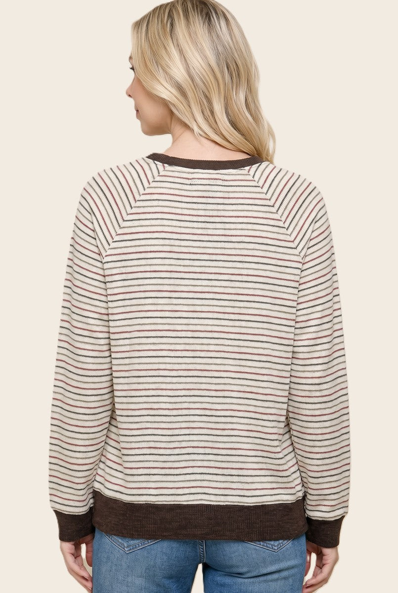 woman wearing a cream and brown striped sweater with raglan sleeves and a ribbed hem
