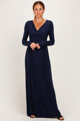 woman wearing a navy long sleeve maxi dress with a twisted bodice and a v-neckline