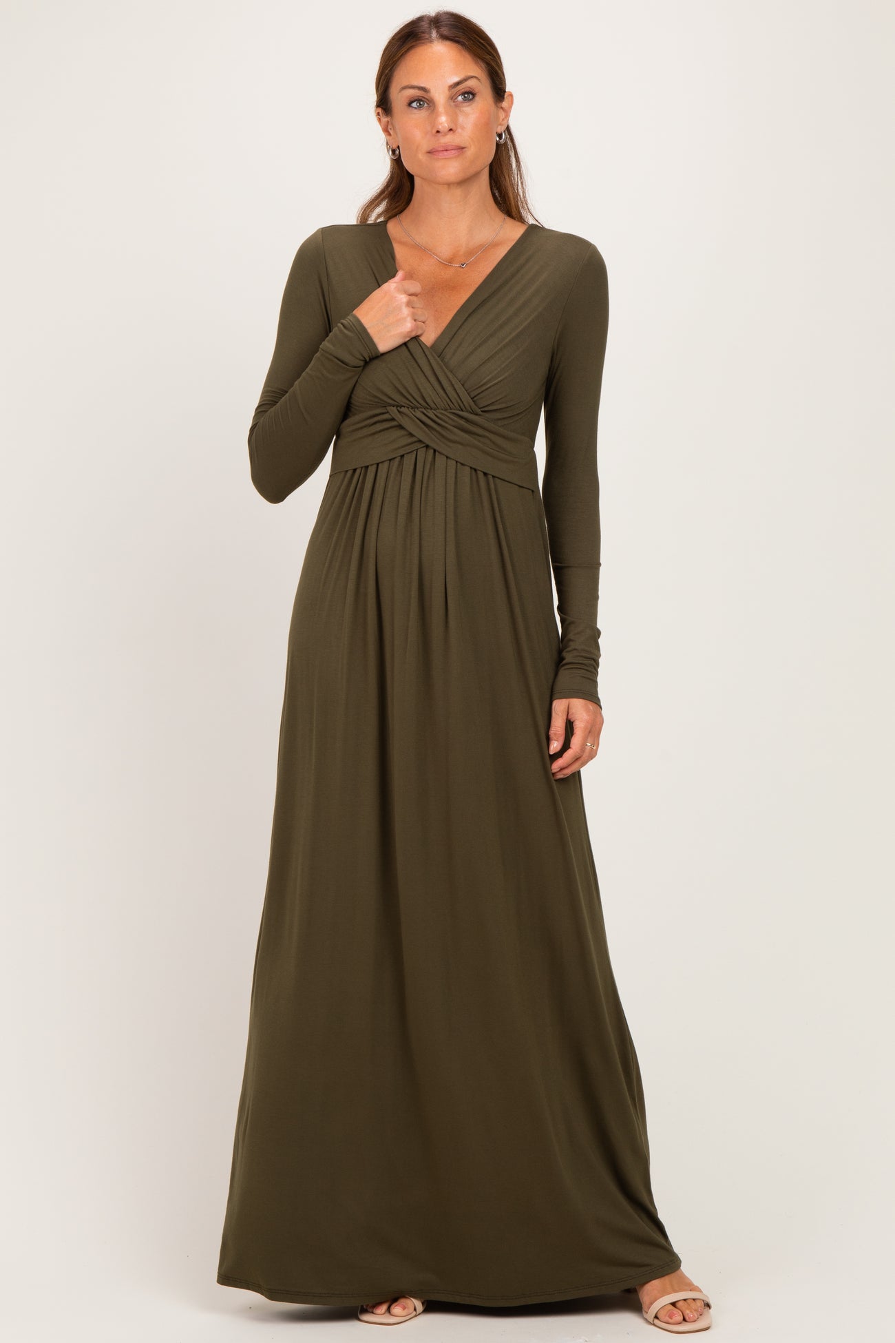 woman wearing an olive green long sleeve maxi dress with a wrapped bodice and pleated skirt