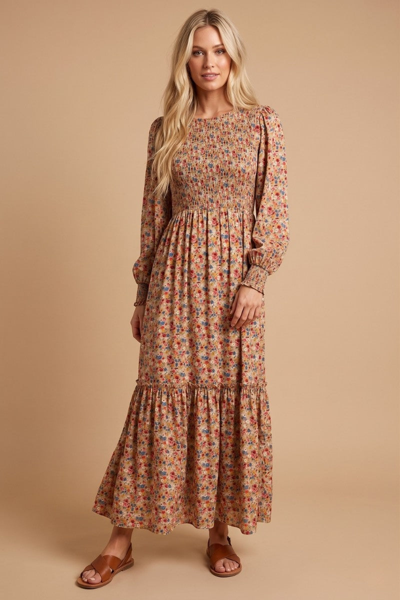woman wearing a long floral maxi dress with smocked bodice and tiered hem, standing on a neutral background