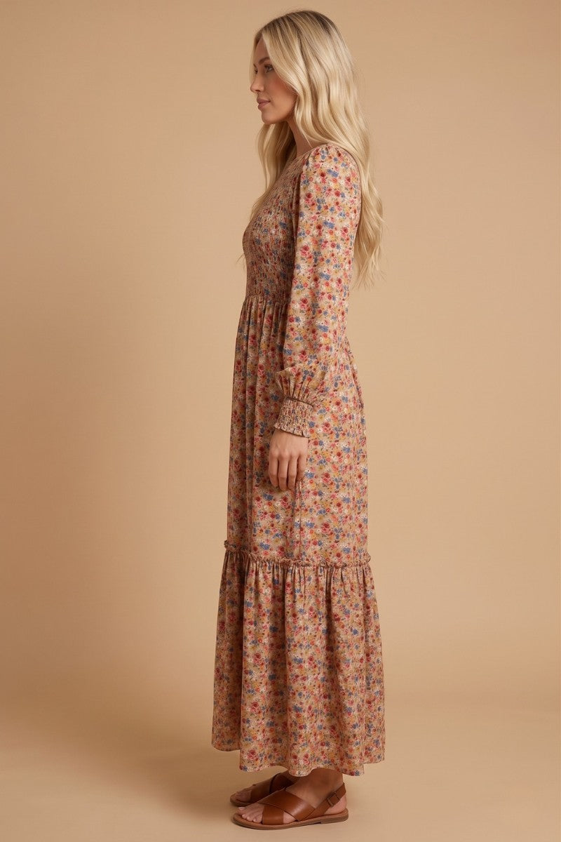 woman wearing a long floral maxi dress with long sleeves and a tiered hem, styled with brown sandals