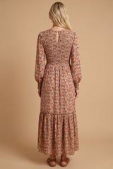 woman wearing a long floral maxi dress with smocked bodice and tiered skirt, seen from the back