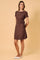 woman wearing a brown short sleeve dress with a tie detail at the waist and white flats