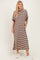 woman wearing a brown and white striped maxi dress with short sleeves and side pockets, standing in white sneakers