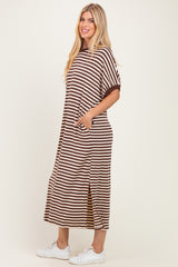 woman wearing a brown and white striped maxi dress with pockets and side slits, styled with white sneakers