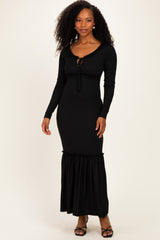 woman wearing a black ribbed maxi dress with long sleeves and ruffle hemline