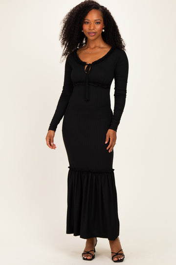 woman wearing a black ribbed maxi dress with long sleeves and ruffle hemline